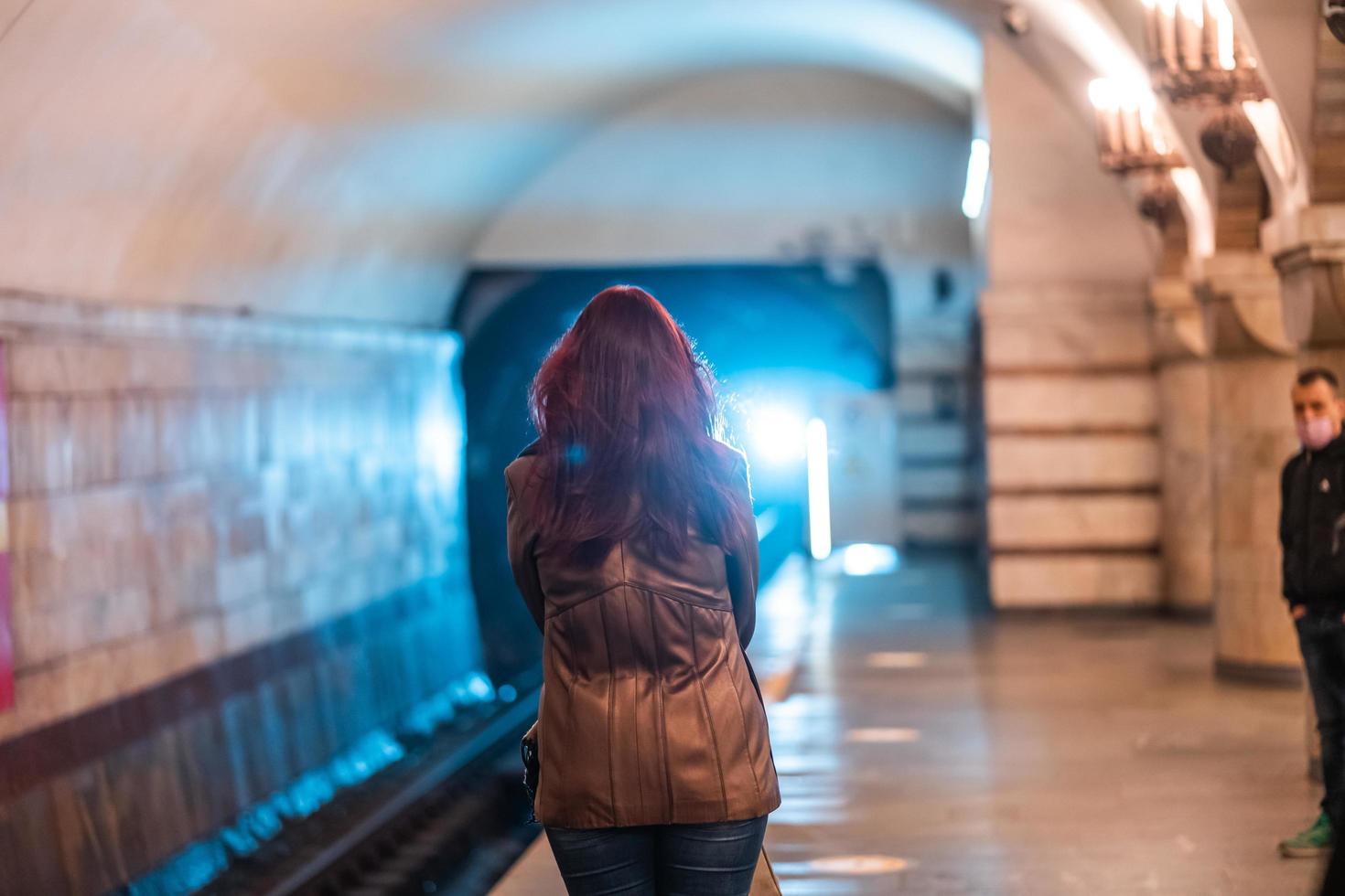 Frau wartet an einer U-Bahnstation in Kiew. foto