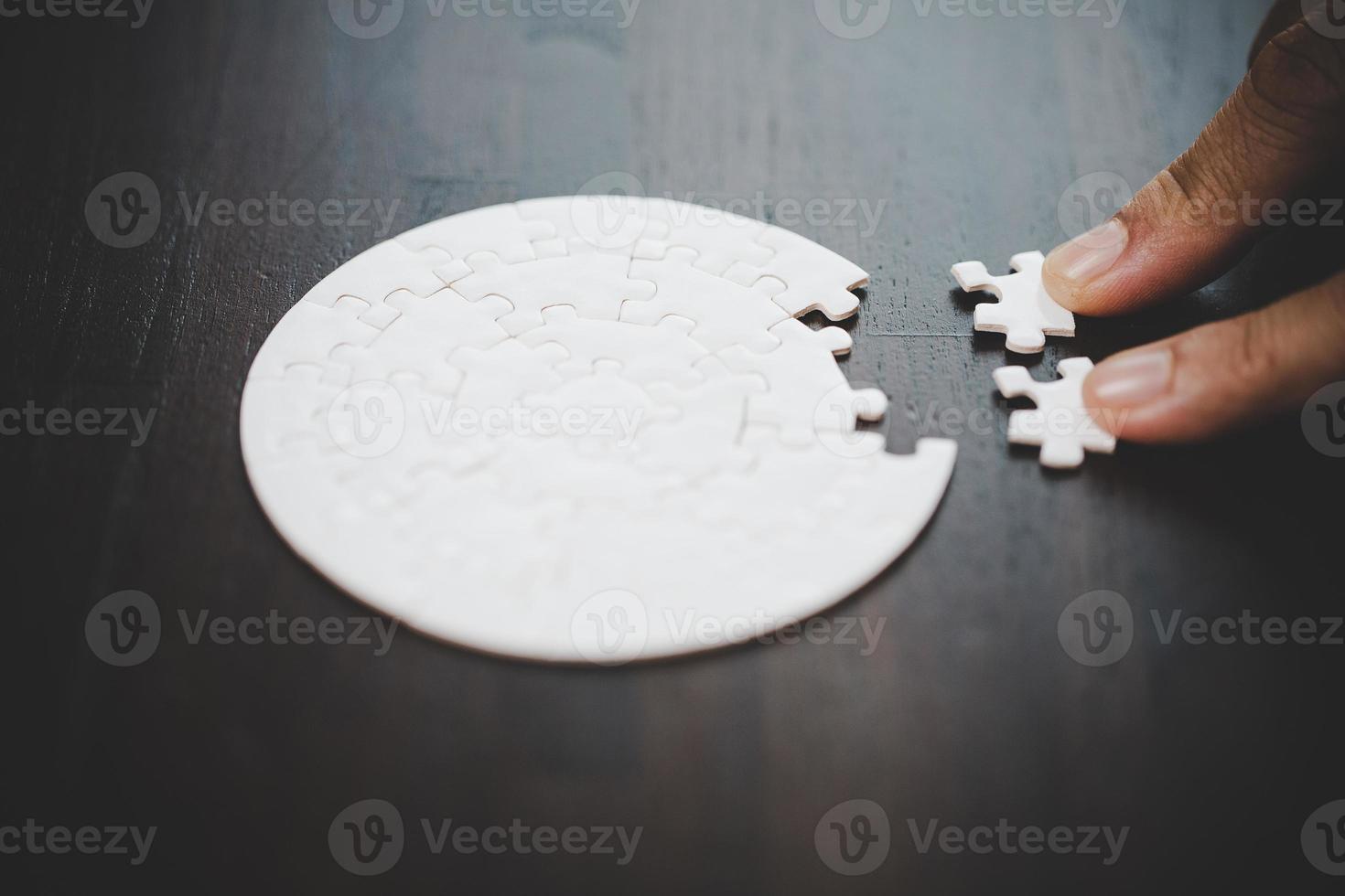 Geschäftsfrau-Personenhand mit Puzzleteilidee für Strategie und Lösung. Closeup Teil von zwei weißen Puzzles verbinden sich. konzept des gemeinsamen zusammenarbeitserfolgs teamwork-problem unternehmensteam. foto