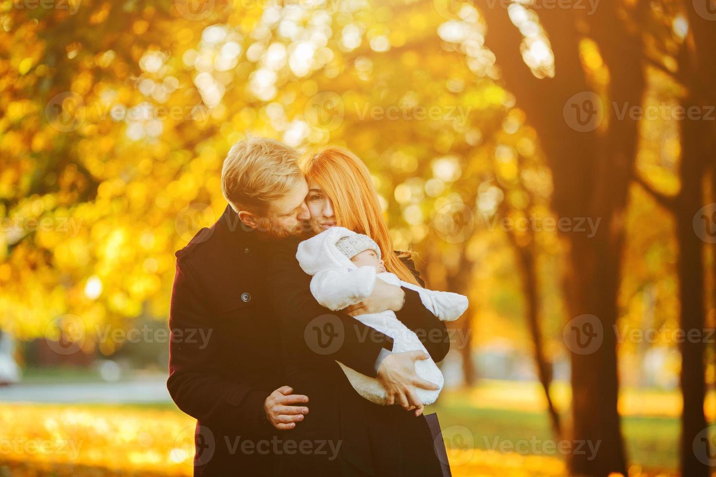 junge Familie und neugeborener Sohn im Herbstpark foto