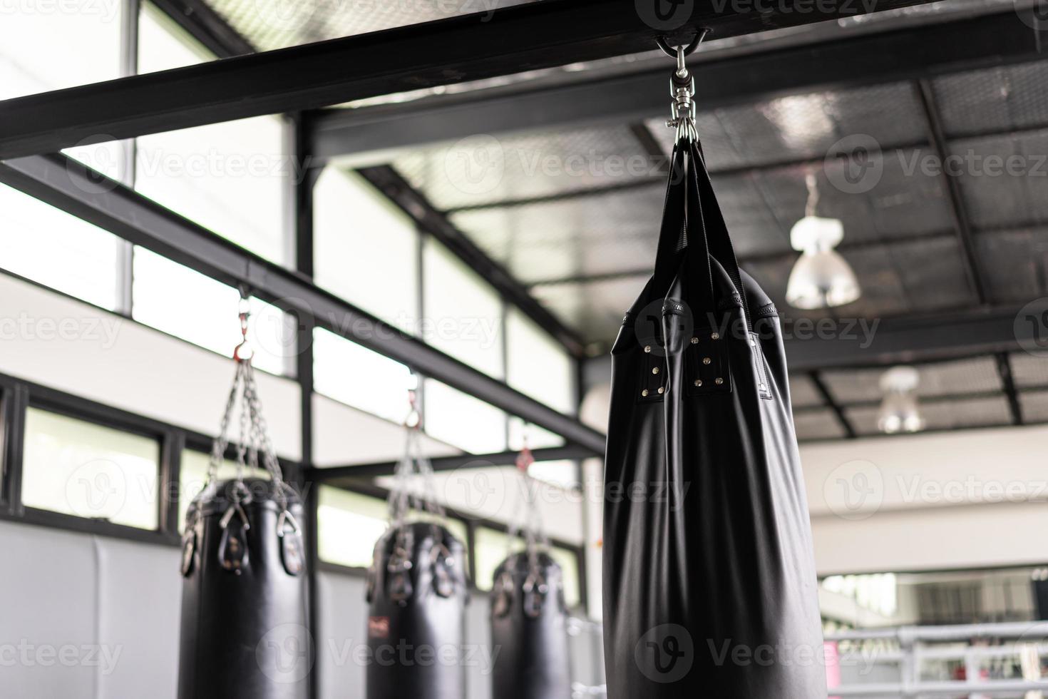 Viele schwarze Sandsäcke für Boxer im Fitnessstudio. foto