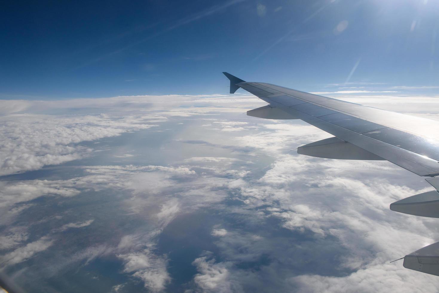 Flügel eines Flugzeugs fliegt über den Wolken foto
