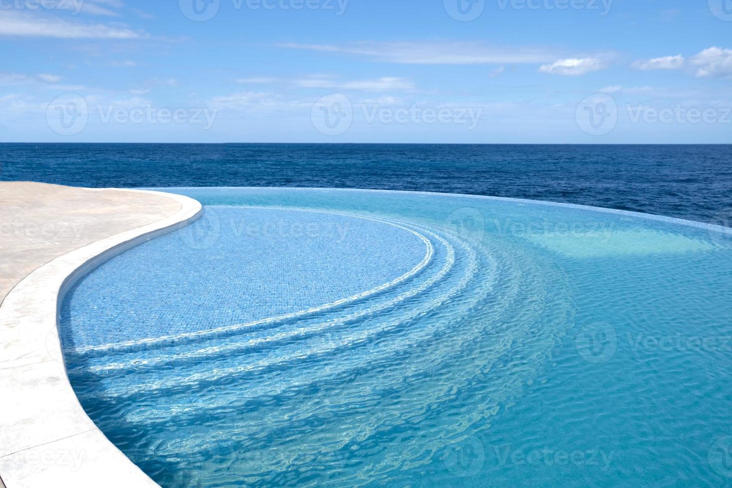 der Wind lässt Wasser kräuseln. Meerwasserpool mit Treppe zum Entspannen. blaue klare wasseroberfläche im schwimmbad. sommerferien- und ruhekonzept. Bodenmuster aus blauen Keramikfliesen. foto