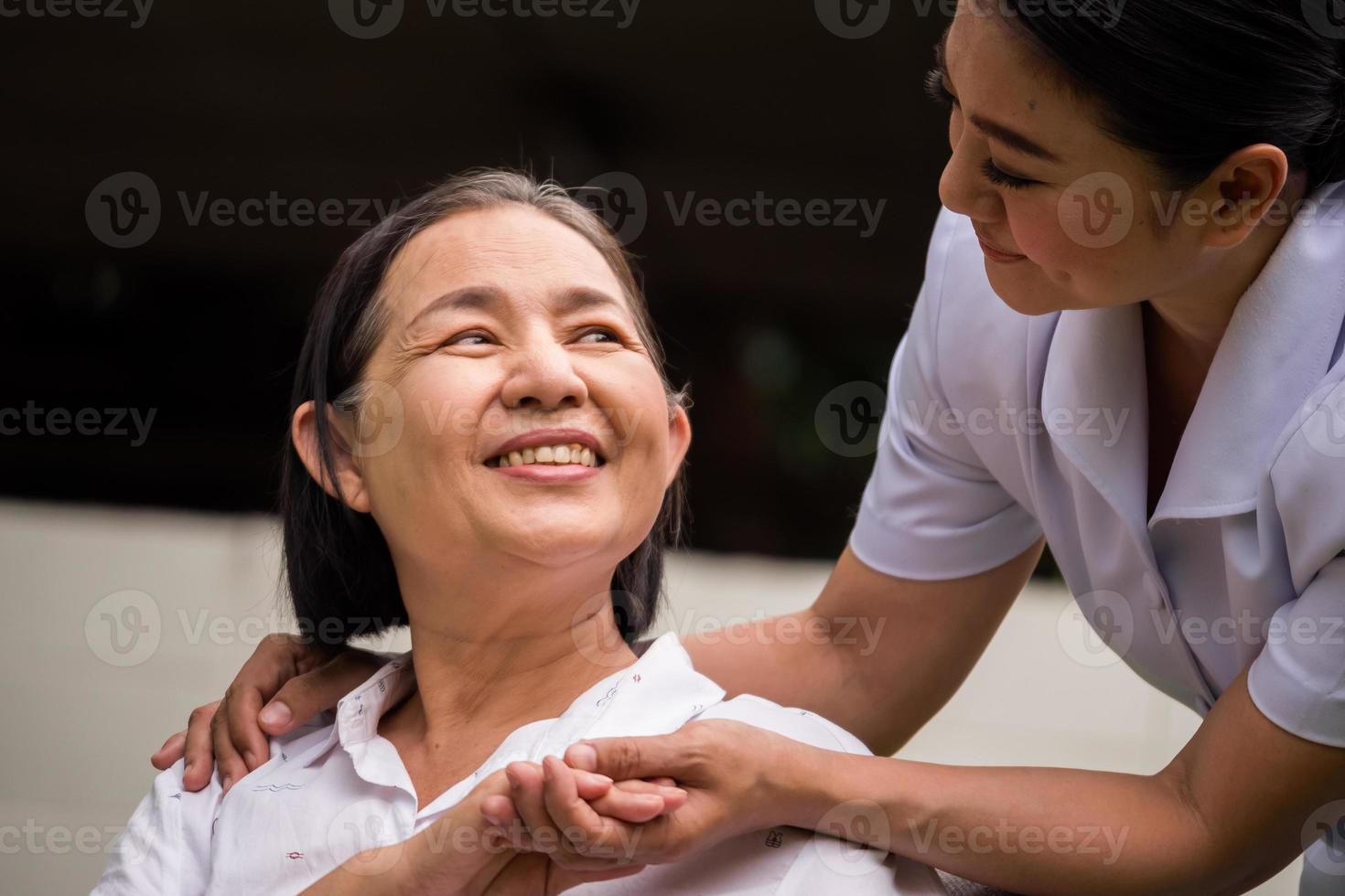 Schöne Krankenschwester, die sich um die Patientin im Krankenhauspark kümmert foto