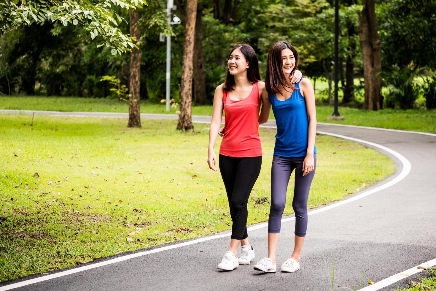 attraktive junge frauen, die nach dem training in einem park spazieren gehen foto