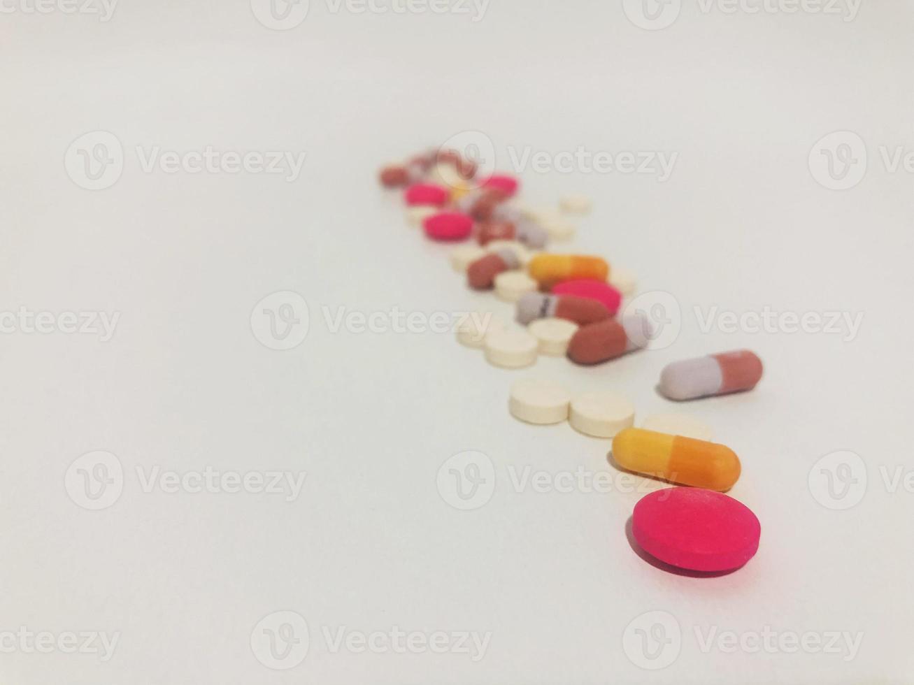 Reihe von Medizinpillen oder Tabletten auf einem einzigen weißen Hintergrund. foto