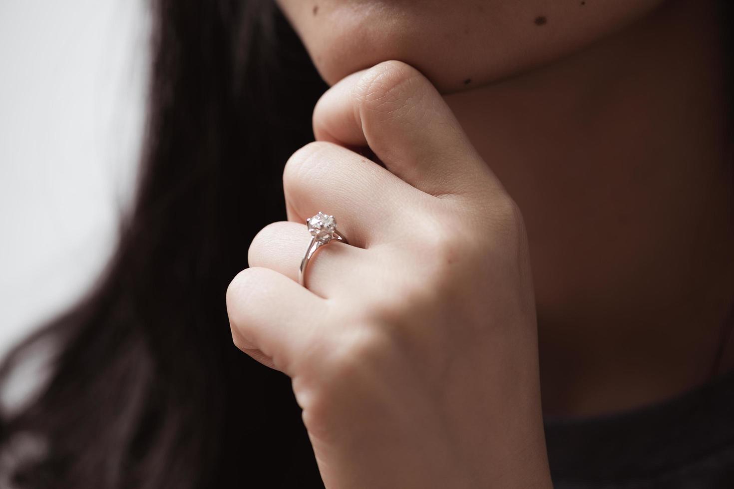 Nahaufnahme eines eleganten Verlobungsdiamantrings am Finger der Frau foto