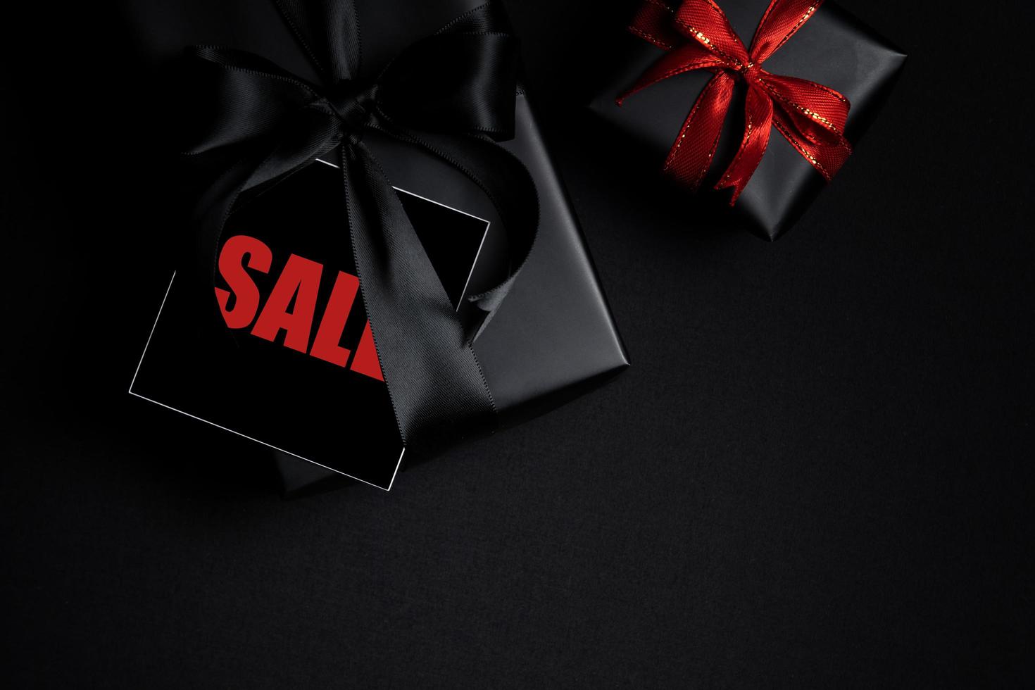 Draufsicht auf schwarzen Freitag-Verkaufstext mit schwarzer Geschenkbox isoliert auf schwarzem Hintergrund. foto