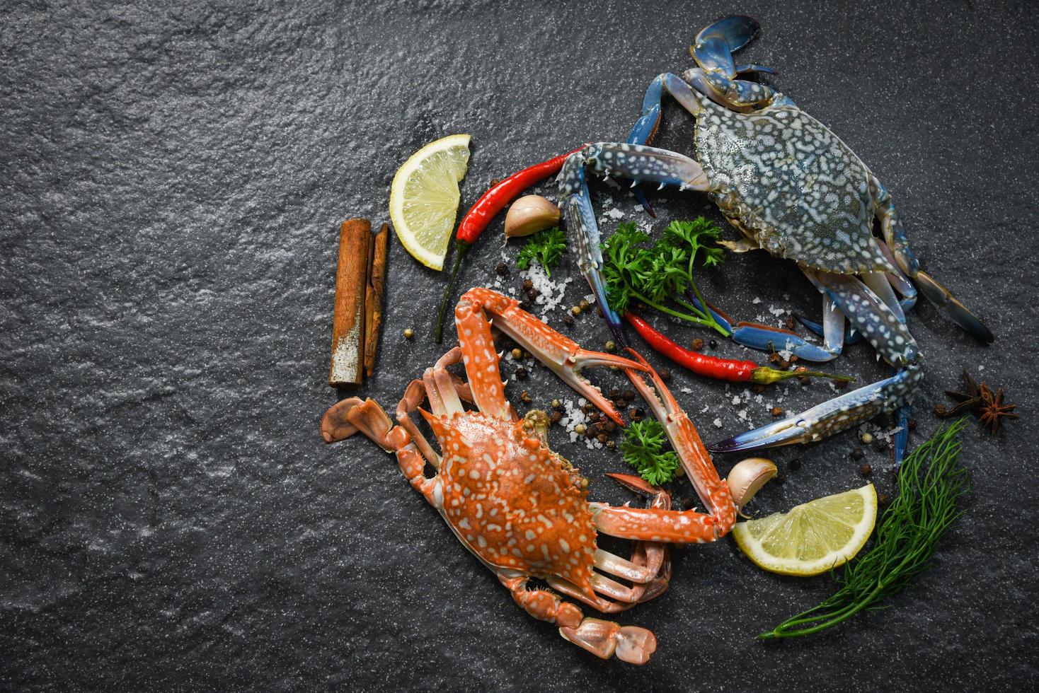 frische rohe Krabben, gekochte Schalentiere, Meeresfrüchte und gedünstete Krabben mit Kräutern und Gewürzen foto