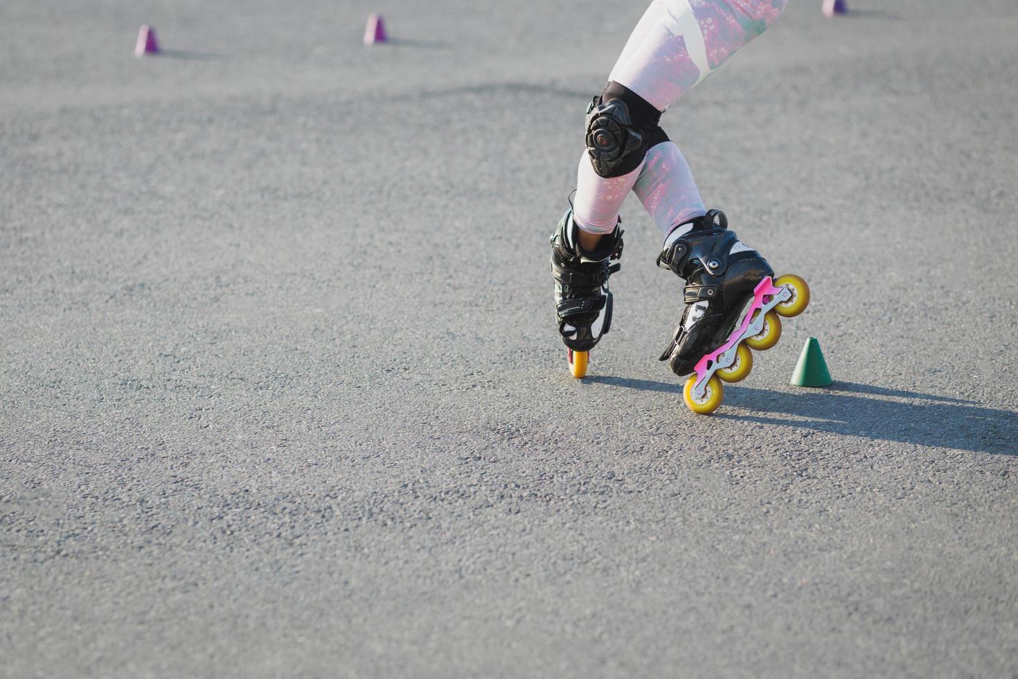 7/8-Aufnahme von Teenager-Inline-Skates auf Asphalt, hat eine Prüfung, trägt Inline-Skates und Schutz auf den Knien. aktives lebensstil-, freizeit- und hobbykonzept foto