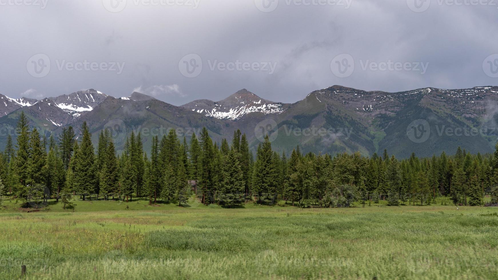 Dunkle, schwere Wolken bedrohen eine Reihe von Berggipfeln in der Nähe des Glacier National Park. foto