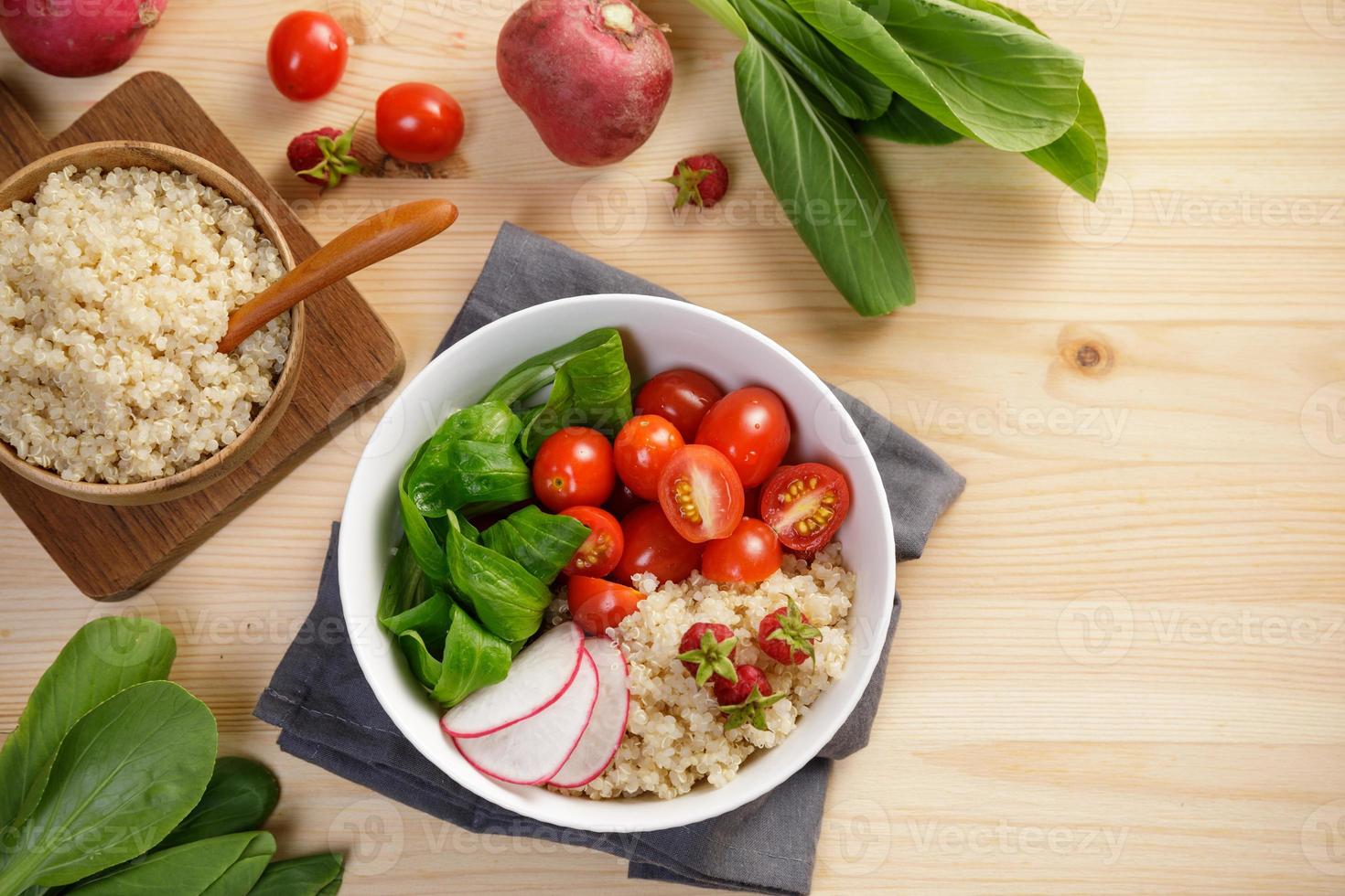 Quinoa-Salat mit Gemüse, Himbeeren und Tomaten auf dem Holztisch. super essen für gesundes und konzept einer ausgewogenen ernährung foto