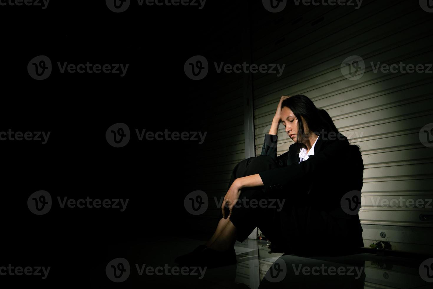 frau deprimiert von traurigem stressschmerz verzweiflungsproblem, person sitzt allein auf geschlossenem geschäft auf korridor mit gefühl einsam verzweifelt verärgert kopf nach unten. kopf in der hand kein ausweg konzept, kopierraum foto