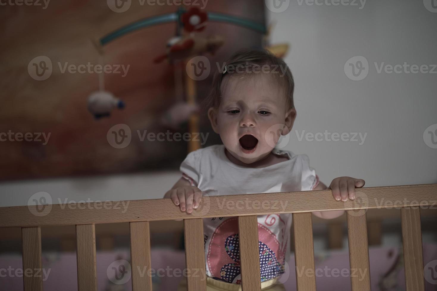 süßes kleines einjähriges baby und macht erste schritte im bett foto