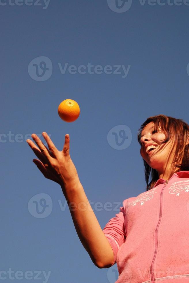 weibliche hand, die iorange in der luft balanciert foto