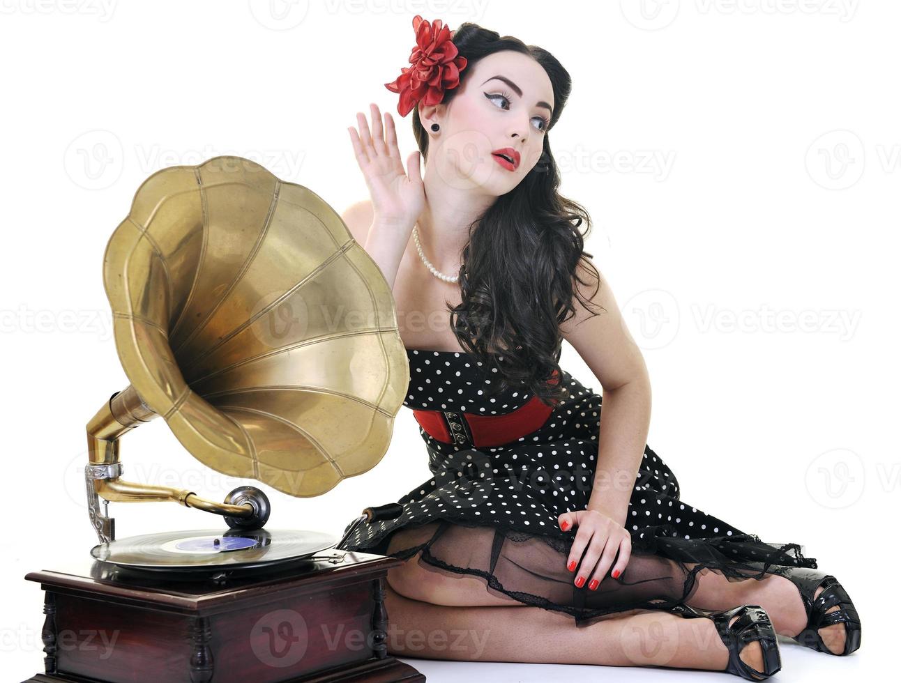 hübsches mädchen, das musik auf altem grammophon hört foto