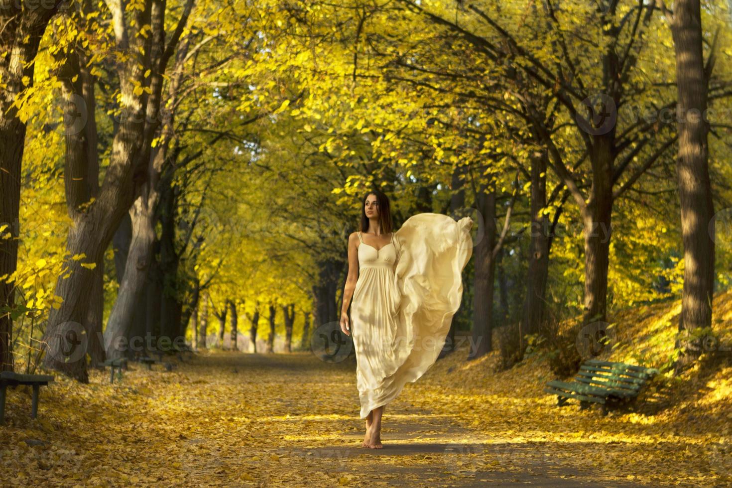 Frau geht im Herbstpark spazieren. foto