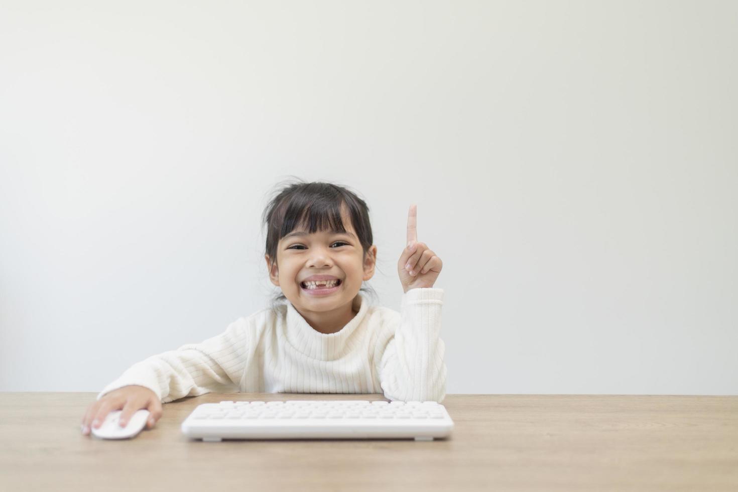 erster Schultag. süße kleine mädchen, die einen laptop verwenden und über ein online-e-learning-system lernen. foto