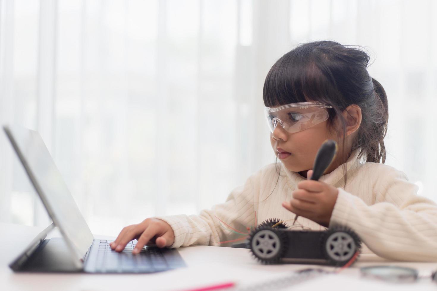 asiatische studenten lernen zu hause in der codierung von roboterautos und elektronischen platinenkabeln in stamm-, dampf-, mathematik-ingenieurwissenschaften-technologie-computercode in der robotik für kinderkonzept. foto