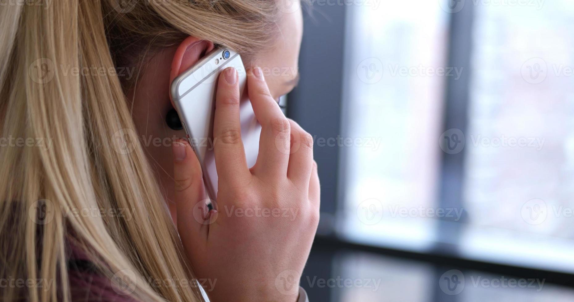 Nahaufnahme einer Geschäftsfrau mit Handy im Büroinnenraum foto