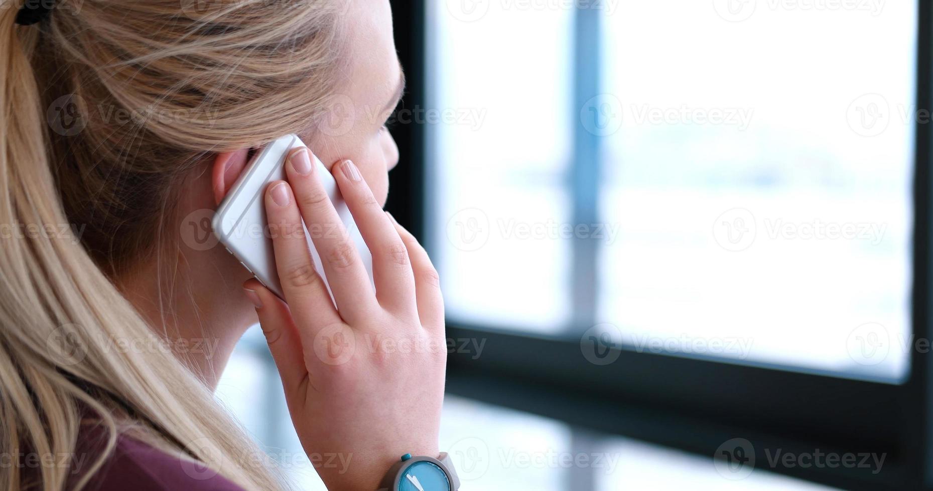 Nahaufnahme einer Geschäftsfrau mit Handy im Büroinnenraum foto