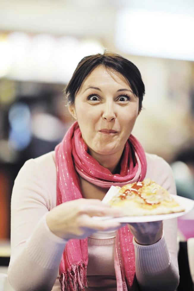 Frau isst Pizza im Restaurant foto