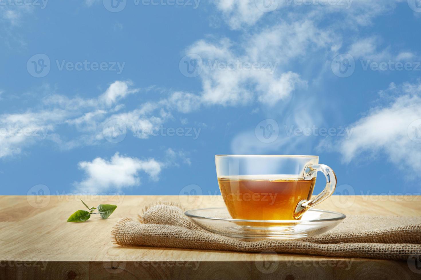 Teetasse mit und Teeblattsacken auf dem Holztisch und dem Himmelshintergrund foto