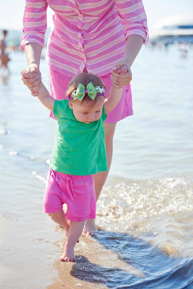 Mama und Baby am Strand haben Spaß foto