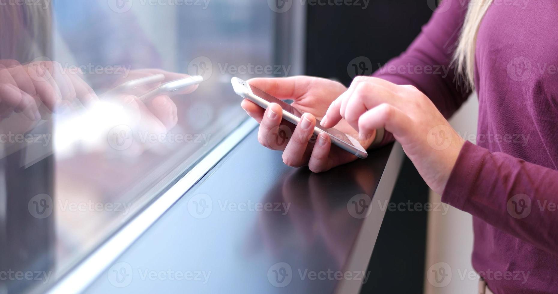 Nahaufnahme einer Geschäftsfrau mit Handy im Büroinnenraum foto