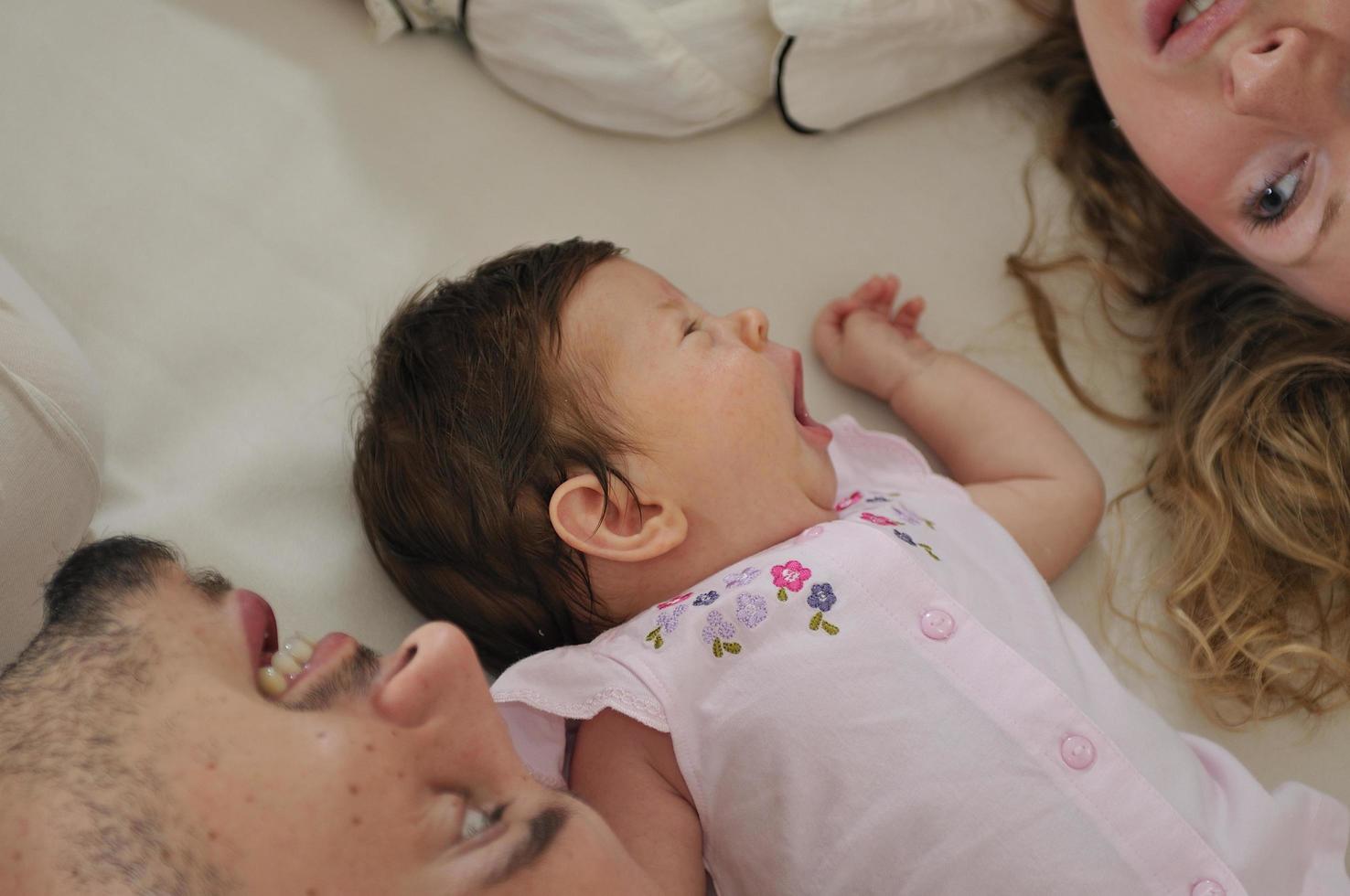 junge familie, die mit niedlichem kleinem baby spielt foto