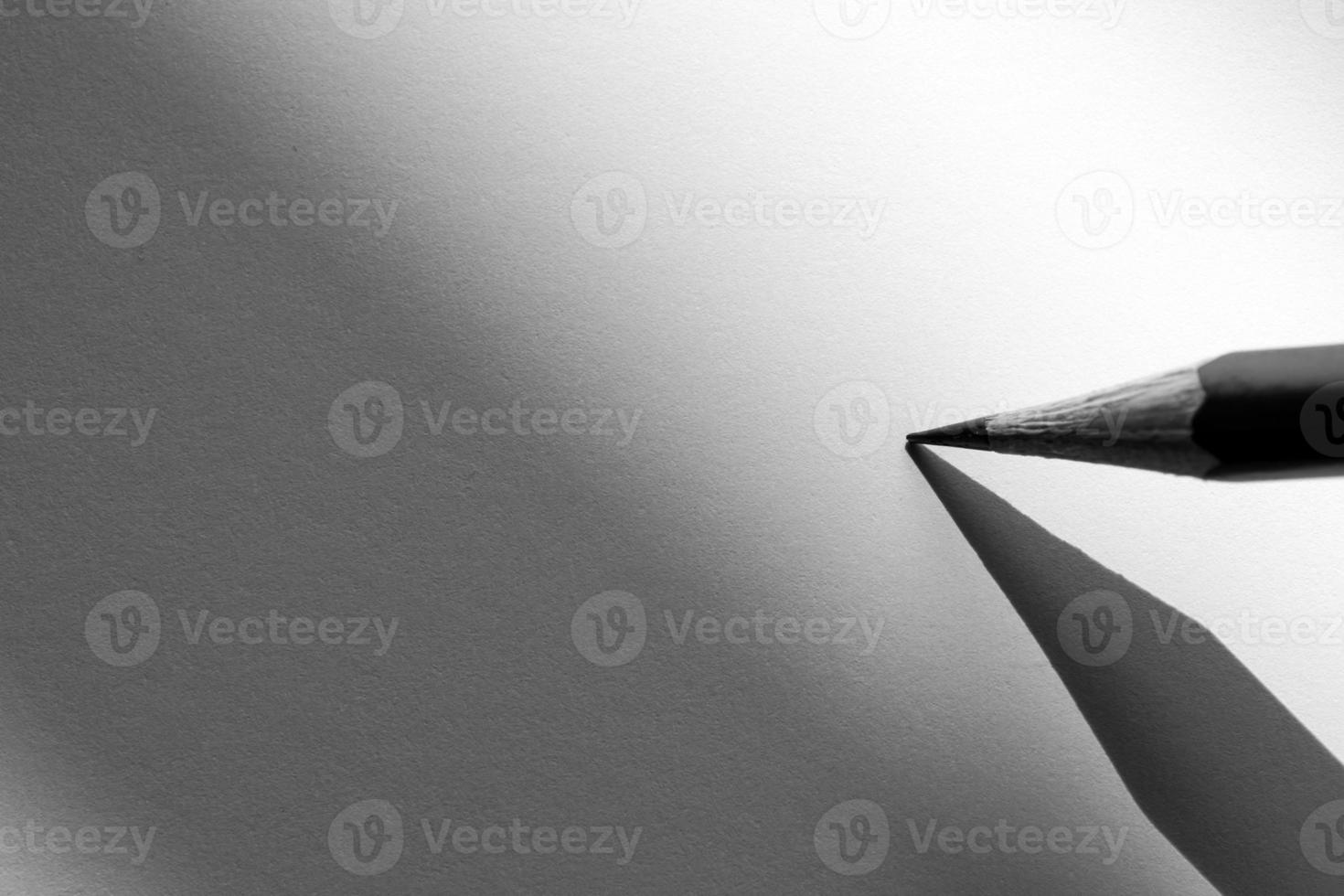 Bleistift hält, um im Schatten auf das Papier zu schreiben foto