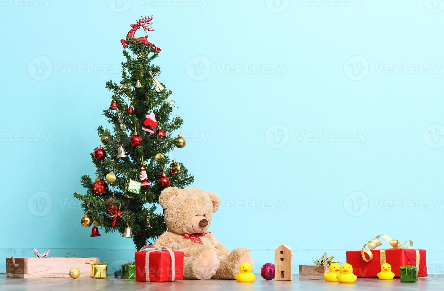 weihnachtsbaum, flagge und weihnachtsschmuck mit spielzeugteddybär auf blauem hintergrund, frohes neues jahr 2017 mit kopienraum foto