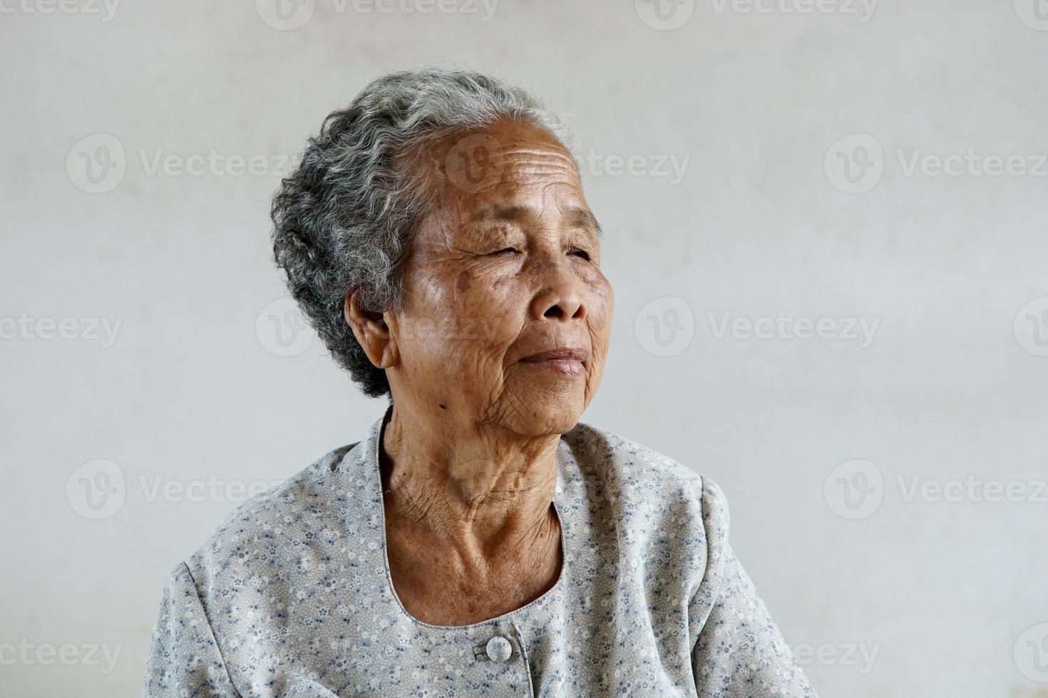 Smilling des glücklichen asiatischen älteren Seniors auf weißem Hintergrund foto