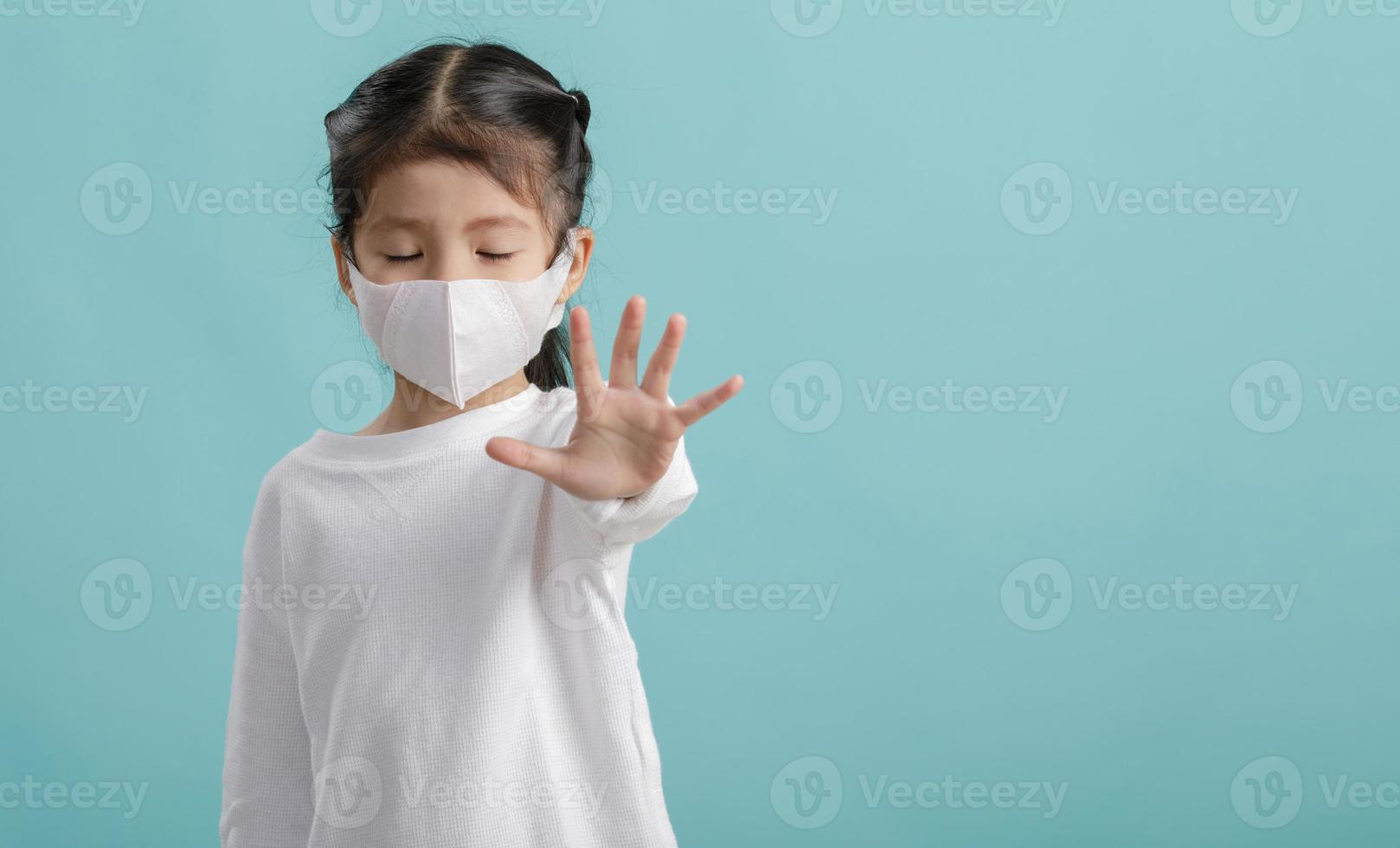 asiatisches kleines mädchen trägt medizinische gesichtsmasken, um sich vor verschmutzung zu schützen foto