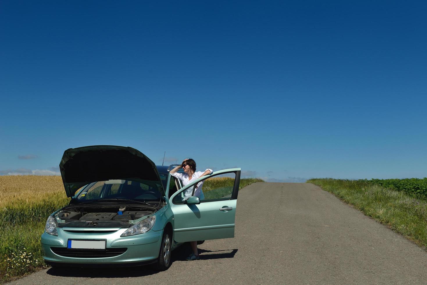 Frau mit kaputtem Auto foto