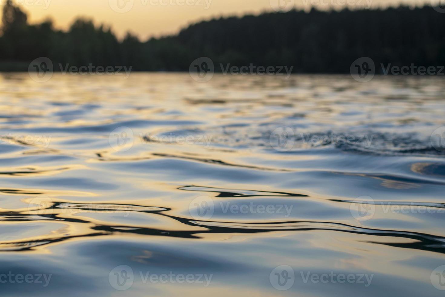 atmosphärischer sonnenuntergang hinter bäumen und reflexion im wasser. foto