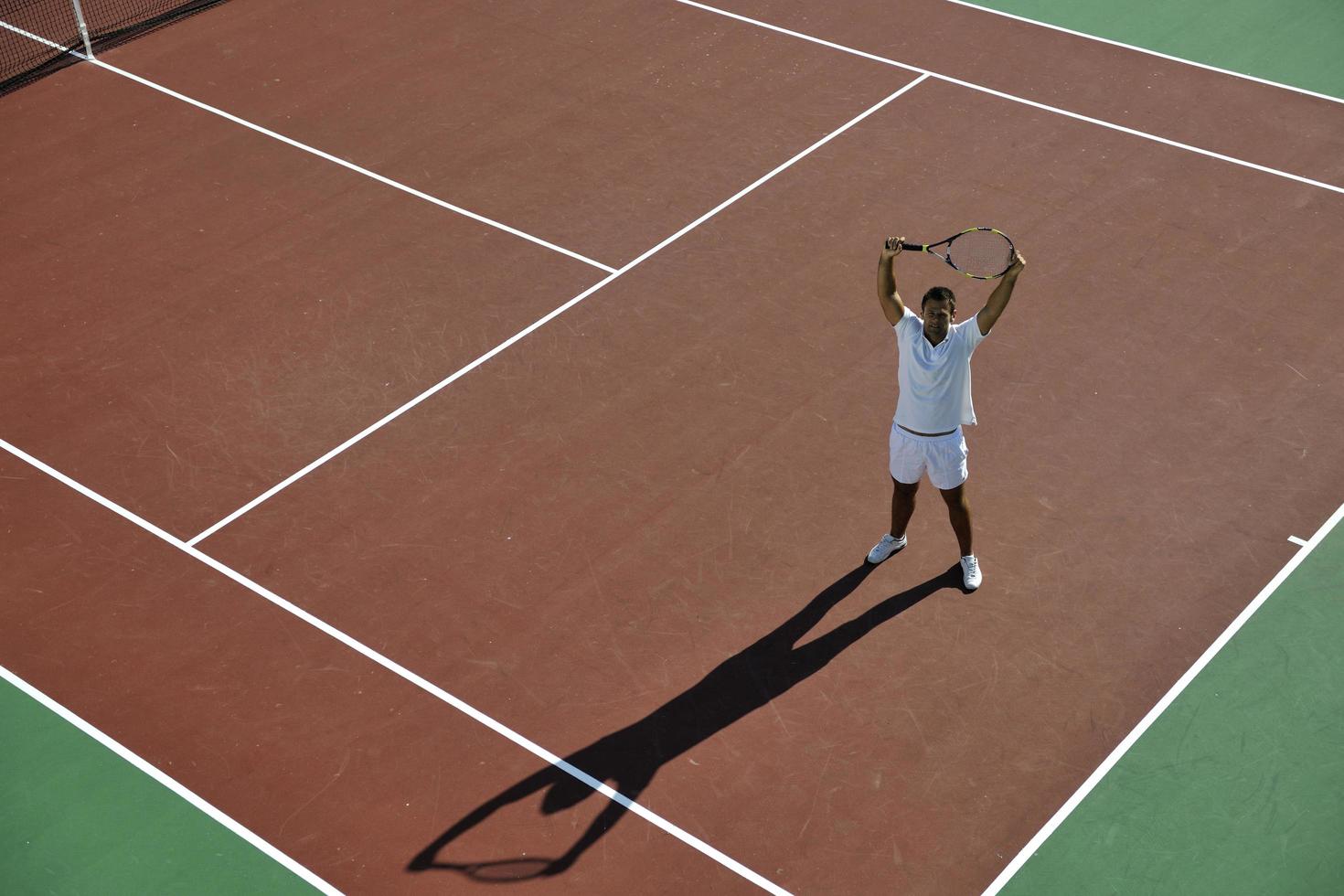 junger mann spielt tennis foto