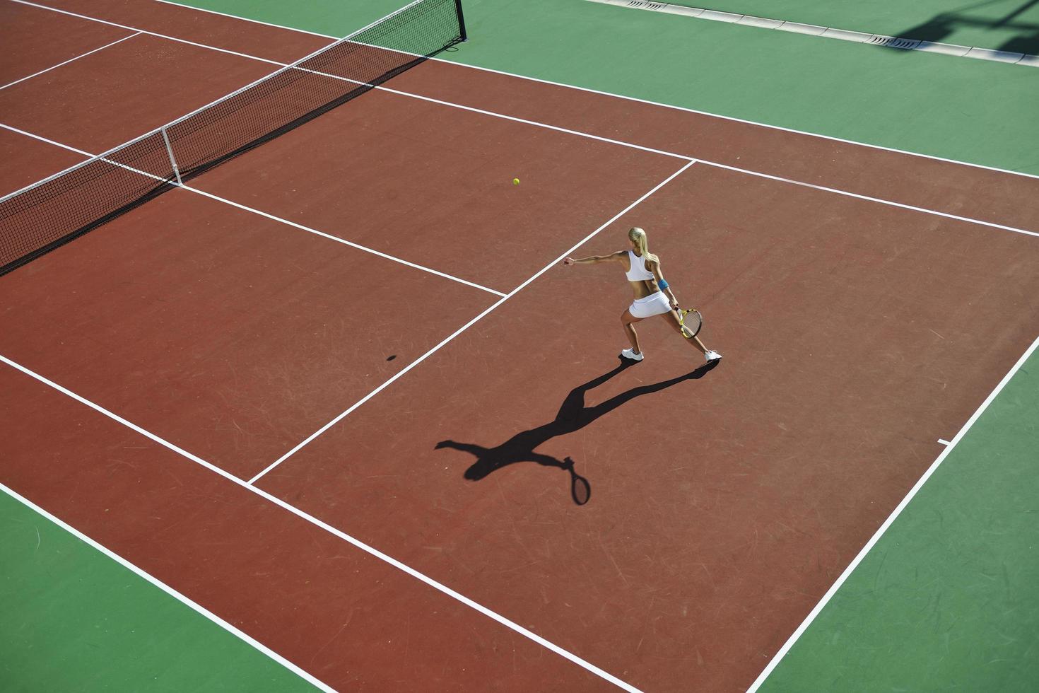 junge Frau spielt Tennis im Freien foto