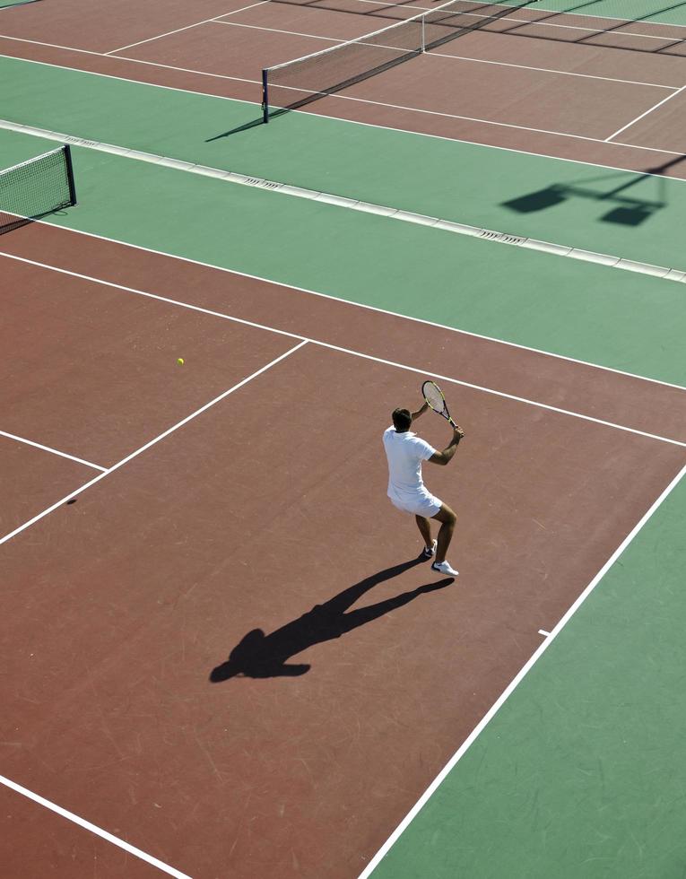 junger mann spielt tennis foto