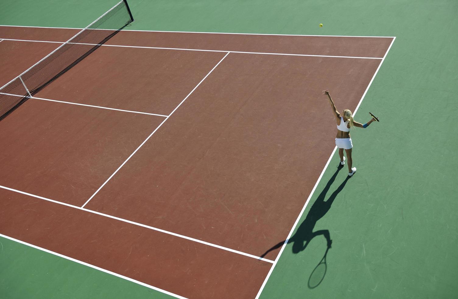 junge Frau spielt Tennis im Freien foto