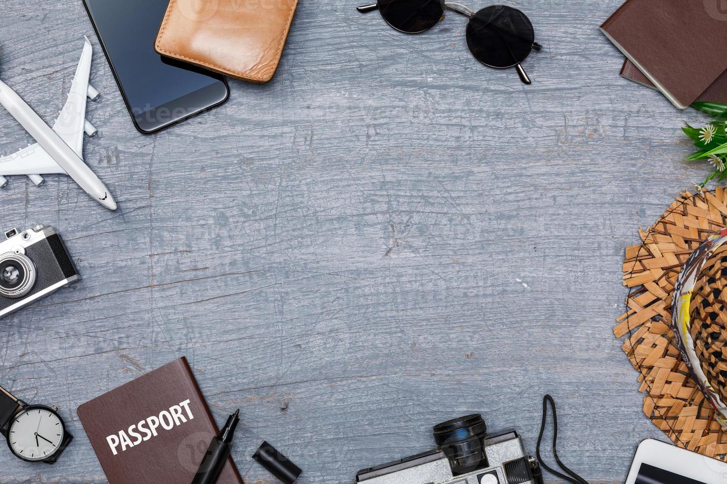 reisezubehör mit reisepass, büchern mit reiseplan, brieftasche, kamera, hut, rucksack und flugzeugspielzeug auf blauem holzschreibtisch, draufsicht mit kopierraum, reisekonzepthintergrund foto