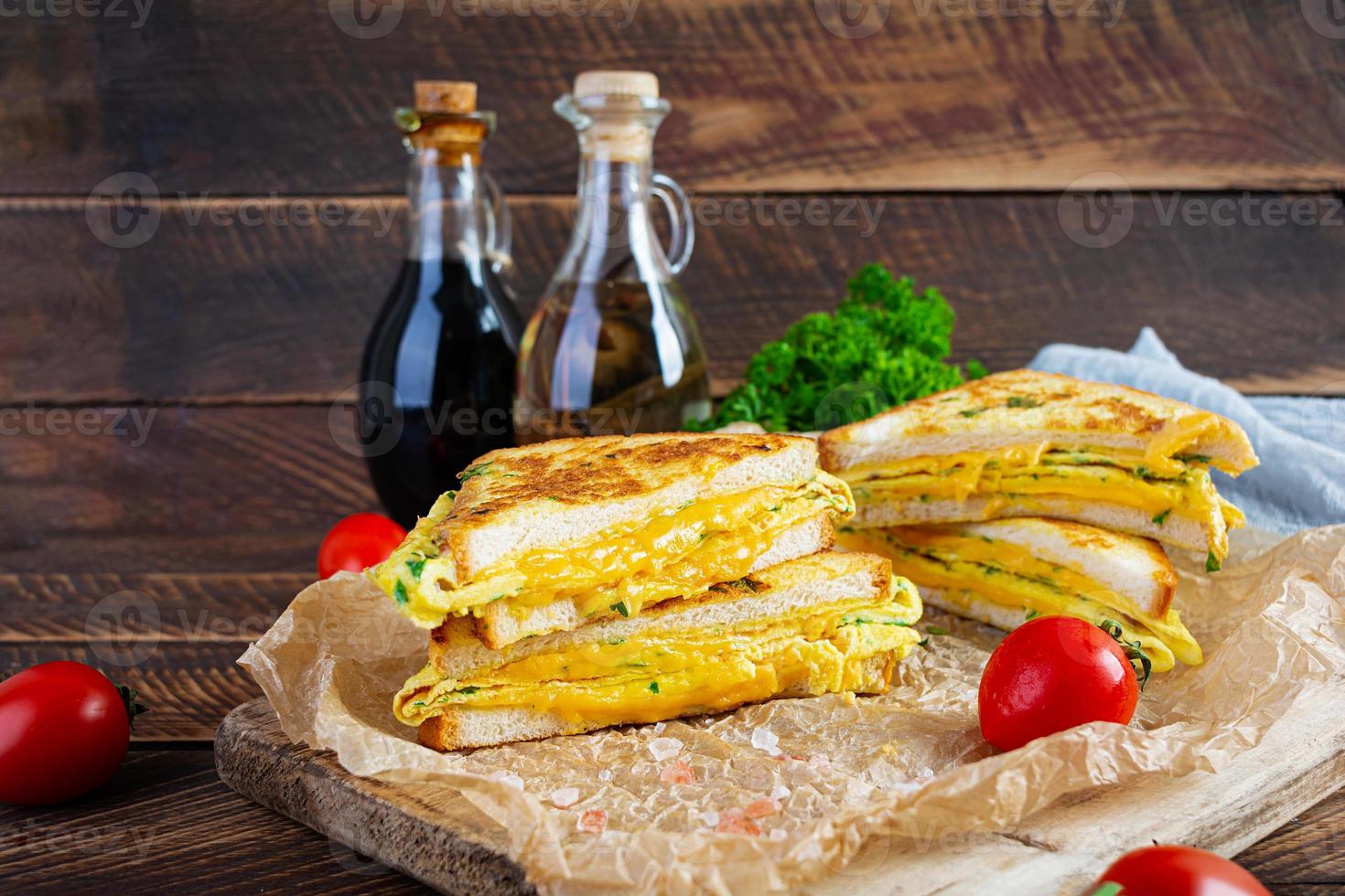 gerösteter French Toast mit Schinken, Ei, Kräutern und Käse-Cheddar. leckeres gegrilltes Frühstückssandwich foto