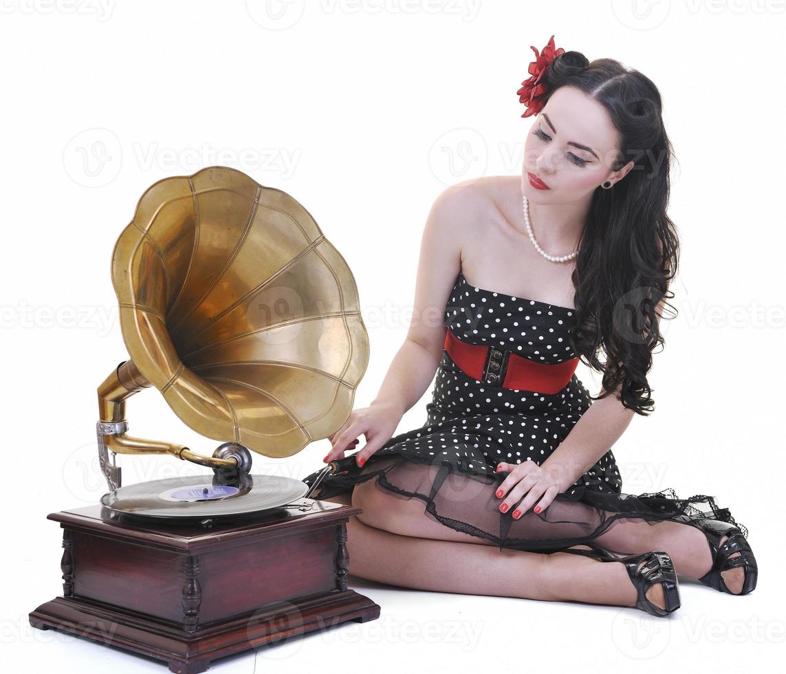 hübsches mädchen, das musik auf altem grammophon hört foto