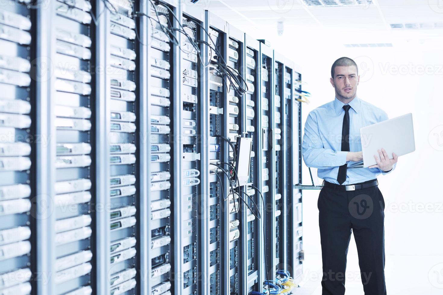 Geschäftsmann mit Laptop im Netzwerkserverraum foto