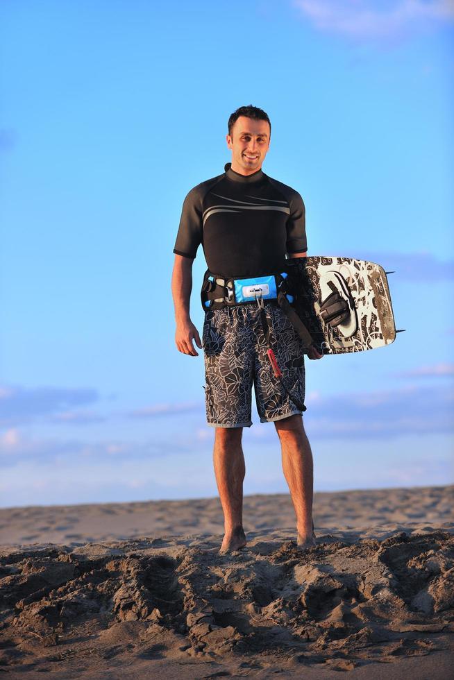 Porträt eines jungen Kitsurf-Mannes am Strand bei Sonnenuntergang foto