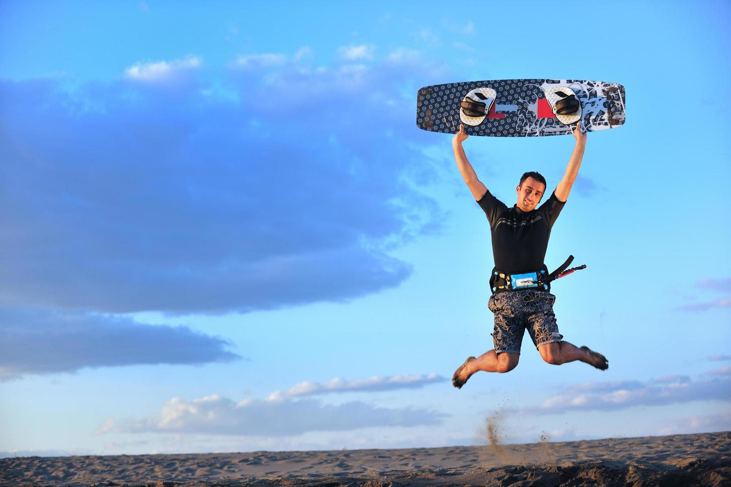 Porträt eines jungen Kitsurf-Mannes am Strand bei Sonnenuntergang foto