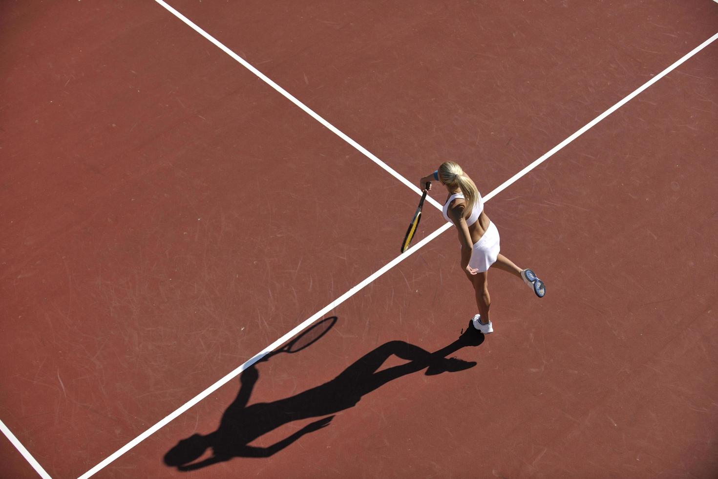 junge Frau spielt Tennis im Freien foto