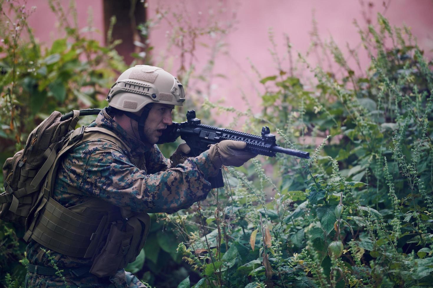 soldat in aktion, der auf waffenlaservisieroptik abzielt foto