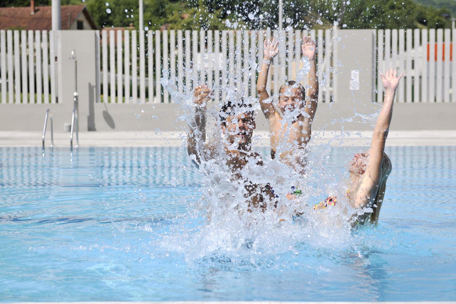 glückliche junge familie hat spaß am schwimmbad foto