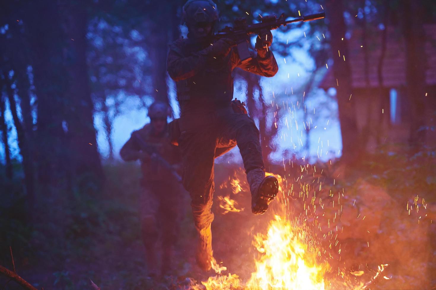 Soldat in Aktion bei Nacht beim Springen über Feuer foto