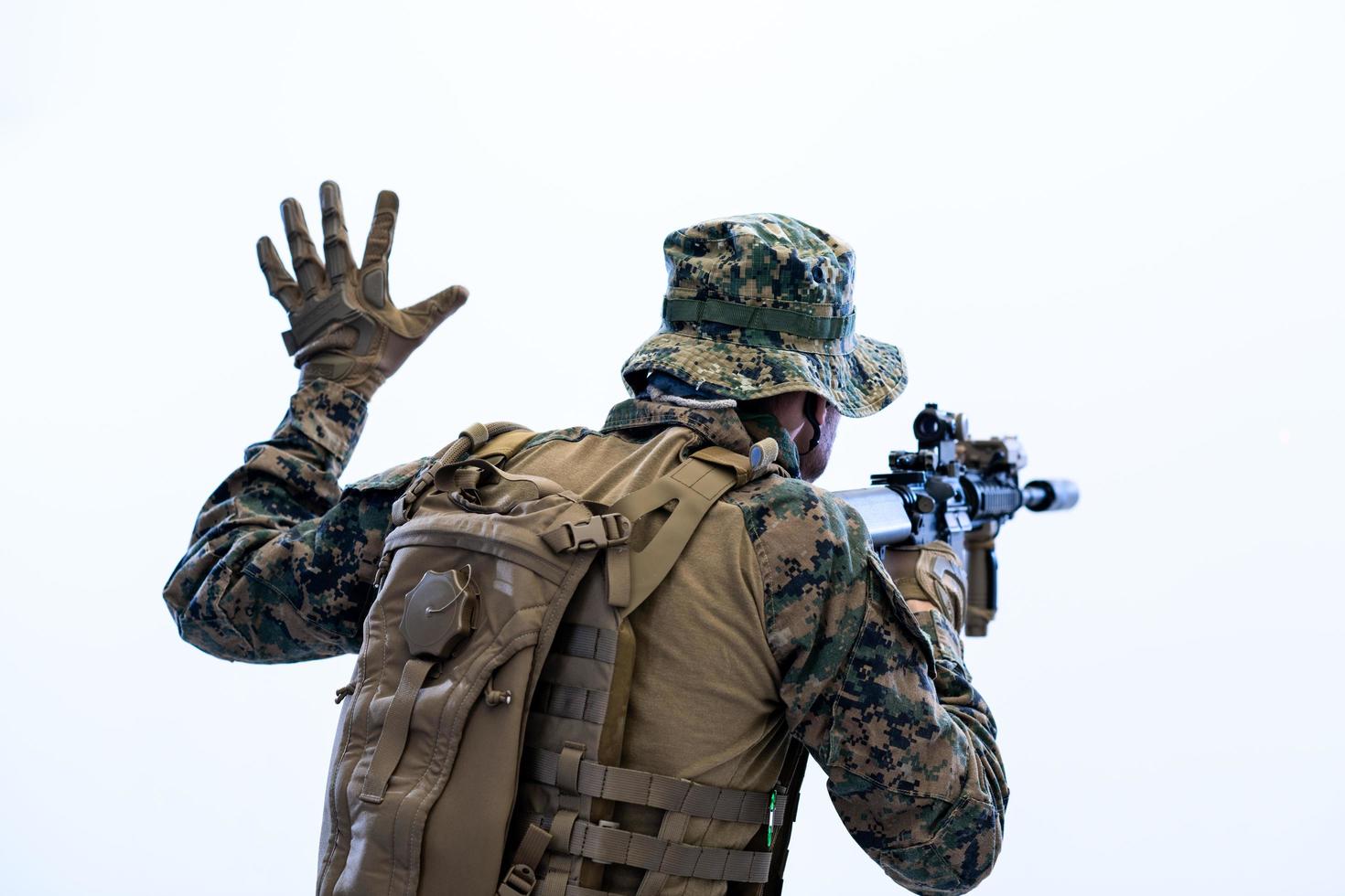 Soldat in Aktion, der dem Team per Handzeichen Befehle erteilt foto